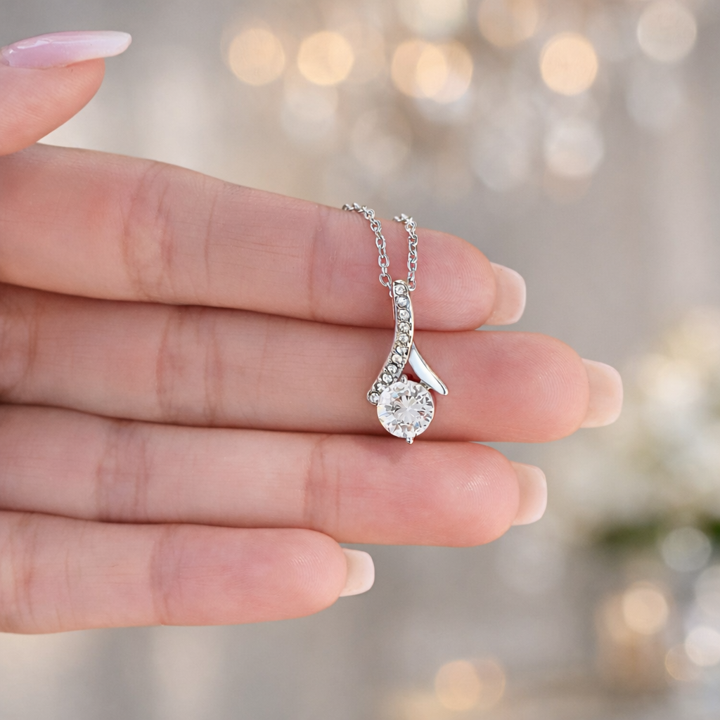 Celebrate love with the dazzling Alluring Necklace, featuring CZ stones and a ribbon pendant — a timeless gift for her to cherish.
